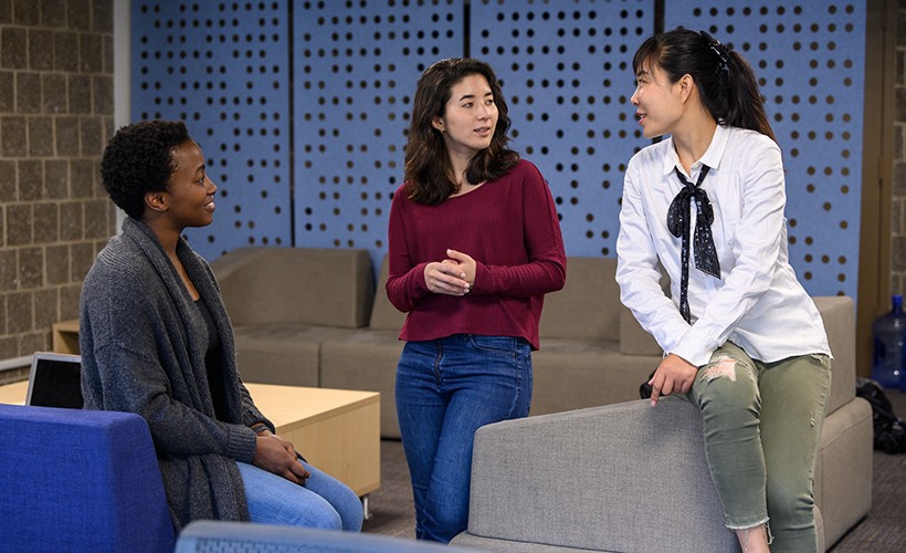 Graduate students talking in the International Student Services office.