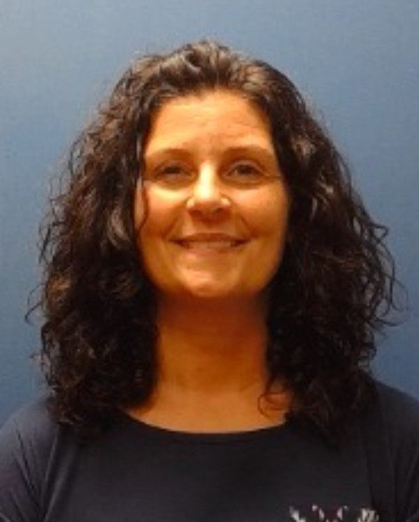 image of Jamie Bennett. Dark curly hair, navy top.