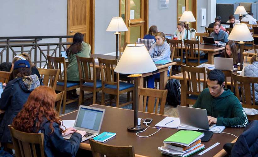 Student sitting at tables in library